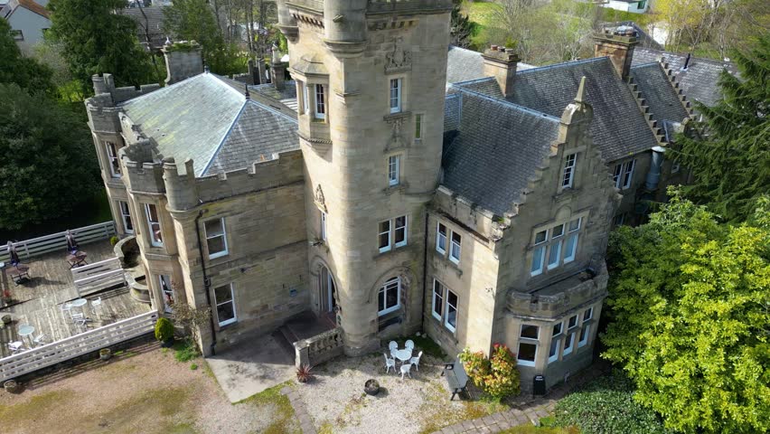 close up aerial of facade front of medieval historic castle hotel in scotland uk circling vintage