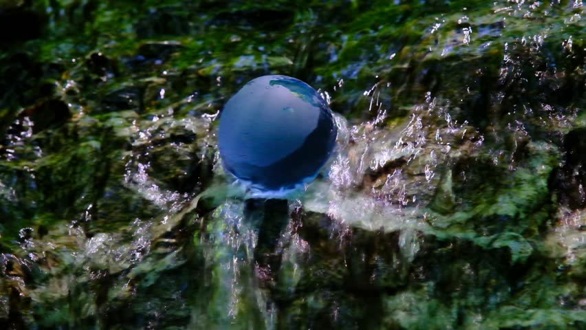 Blue Glass globe on the water stream