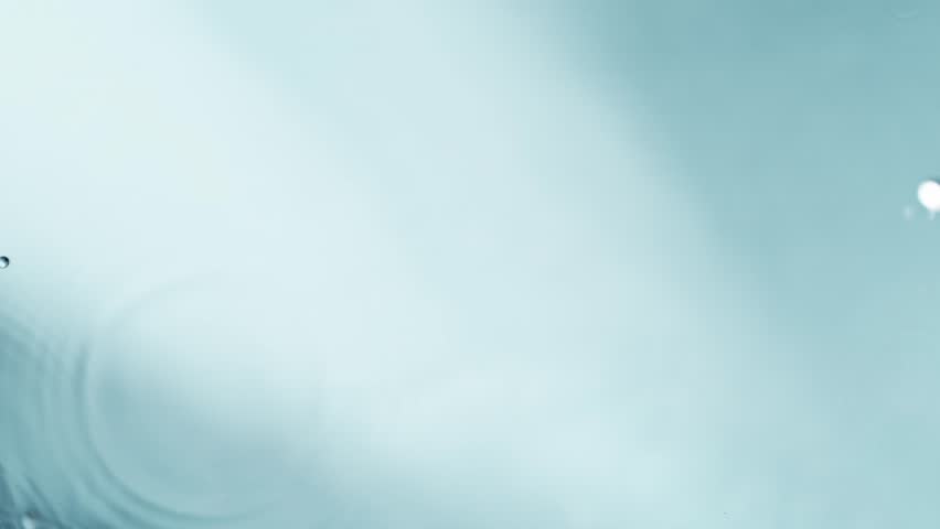 Slow motion of splashing water drops on light blue background , filmed on high speed cinematic camera at 1000 FPS