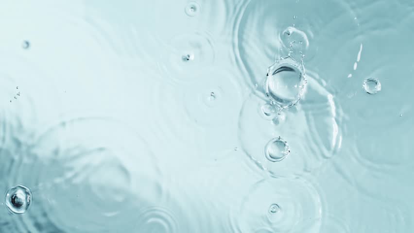 Slow motion of splashing water drops on light blue background , filmed on high speed cinematic camera at 1000 FPS