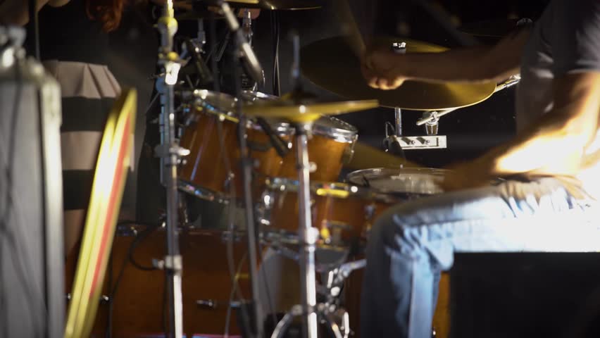 Drummer playing. Person hits the drums. Music, street festival.  Rock concert, lights. Music band rehearsal. 