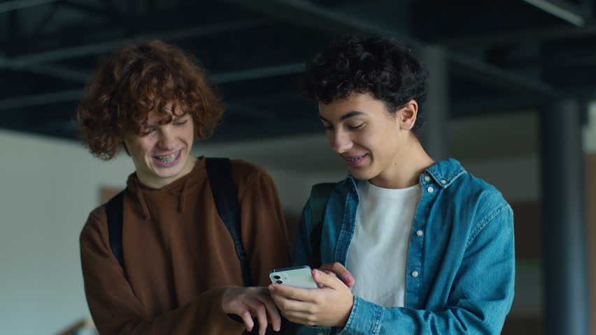 University back to school Caucasian two boys teens pupils students people guys male friends talking smiling laughing talk using mobile phone surprise shocked excited walk studying education teenagers - Powered by Shutterstock - Get 15% off with code: PIKWIZARD15