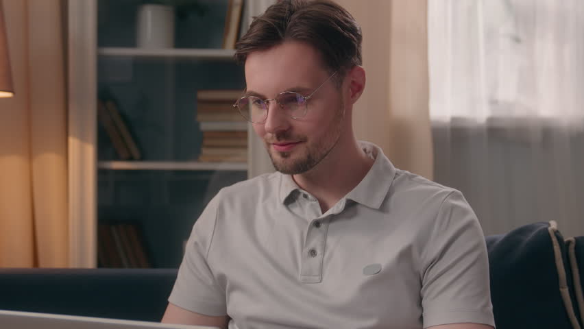 Happy family couple at home Caucasian man guy male working laptop distant freelancer Hispanic Latino woman girl female walk go hug cuddling distract husband off pc throw wife on couch sofa love fun