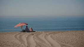 Enjoying peaceful relaxation on a serene beachfront under a pink umbrella on a sunny day - Powered by Shutterstock - Get 15% off with code: PIKWIZARD15