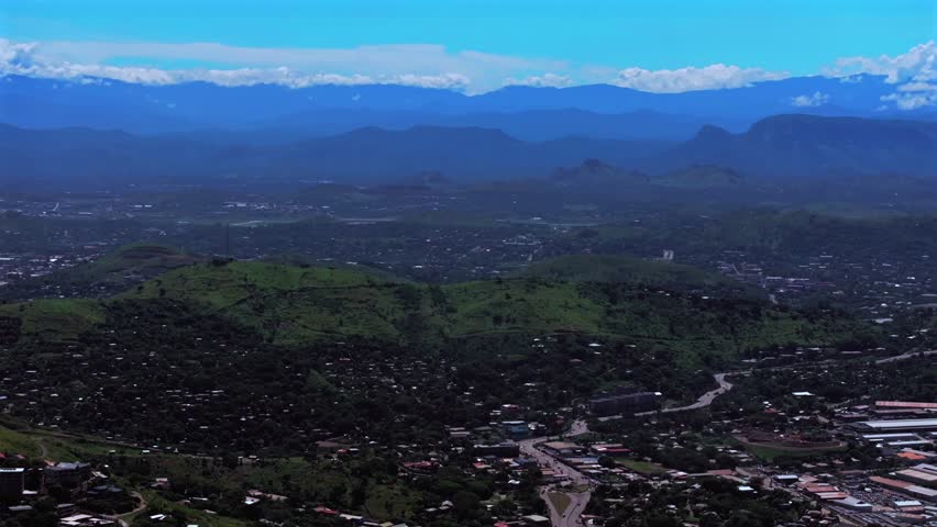Port Moresby capital city business district traffic car highway Papua New Guinea aerial drone Ela Beach Harbour Marina PNG beautiful sunny blue sky morning Crown Hotel Plaza Hilton Coral Sea backwards