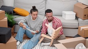 delighted couple, surrounded by moving boxes, constructs a modern wooden shelf, enhancing their new apartment's ambiance during the move - Powered by Shutterstock - Get 15% off with code: PIKWIZARD15