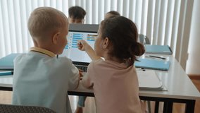 Back view of kids learning to code on laptop when attending computer group class at school - Powered by Shutterstock - Get 15% off with code: PIKWIZARD15