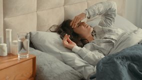 Unhappy woman lying on bed holding head bedroom home girl female headache ill migraine sick rubbing exhaustion healthcare painful suffering unwell upset pressure cephalalgia dizzy temperature disease - Powered by Shutterstock - Get 15% off with code: PIKWIZARD15