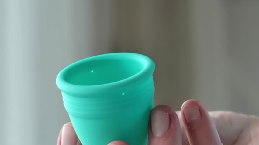 Menstrual cup in a womans hand.Womens periods.reusable silicone menstrual cup.Silicone mestrual cups in hands close-up. Zero vaste and reasonable hygiene and consumption. 4k footage