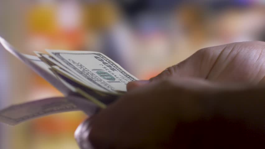 Person holds and counts dollars. Blurred background. Federal Reserve System concept