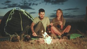 Experience the romance of an evening camping by a campfire at dusk, surrounded by the tranquil wilderness. Enjoy a cozy night together in a beautiful setting under the stars - Powered by Shutterstock - Get 15% off with code: PIKWIZARD15