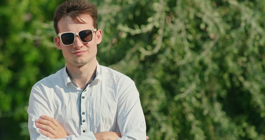 Man in sunglasses unexpectedly drenched with a bucket of water
