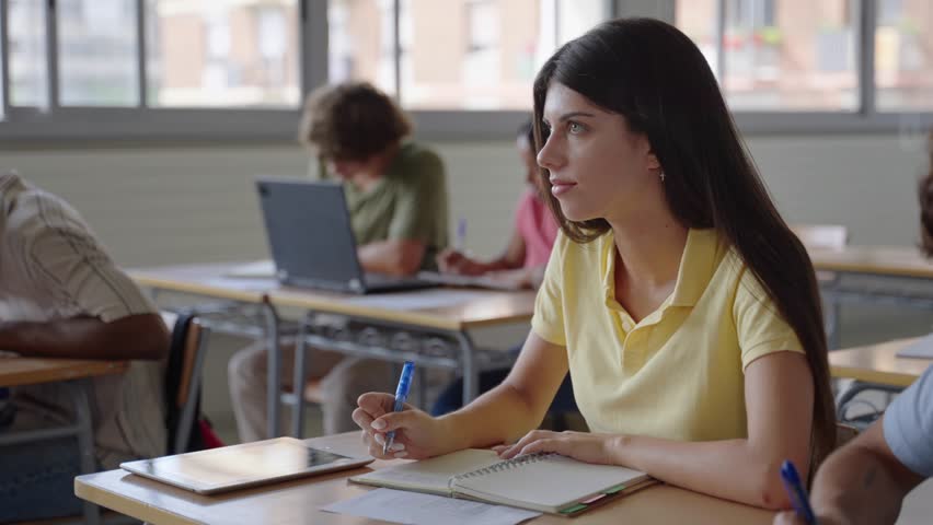 College Student girl writing notes in a Classroom. Multiracial teenagers Study at High School  - Powered by Shutterstock - Get 15% off with code: PIKWIZARD15