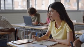 College Student girl writing notes in a Classroom. Multiracial teenagers Study at High School  - Powered by Shutterstock - Get 15% off with code: PIKWIZARD15