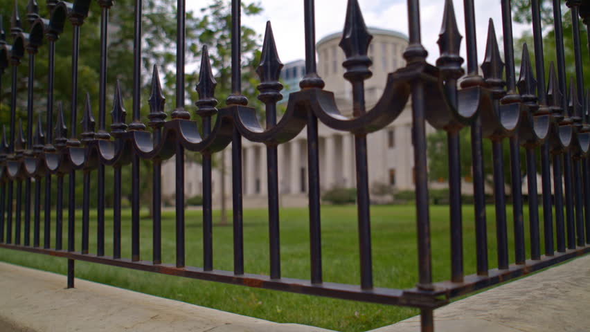 Ohio State Capitol building in Columbus, Ohio with video looking through fence and moving up.