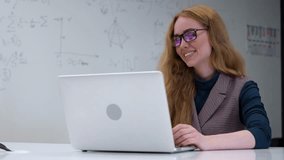 Caucasian woman scientist talking via video connection on a laptop. White board with formulas.  - Powered by Shutterstock - Get 15% off with code: PIKWIZARD15