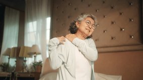 Asian senior mature woman suffering from neck and shoulder pain. Elderly woman feeling pain neck and shoulder by the reason of degenerative disc disease, muscle inflammation or shoulder arthritis. - Powered by Shutterstock - Get 15% off with code: PIKWIZARD15