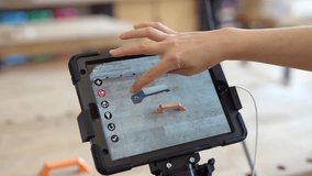 A woman examines a part on a tablet for printing on a 3D printer. - Powered by Shutterstock - Get 15% off with code: PIKWIZARD15