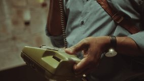 Mature African American detective holding vintage telephone and discussing investigation of criminal case on the call when working late in office. Tilt-up, close-up shot - Powered by Shutterstock - Get 15% off with code: PIKWIZARD15