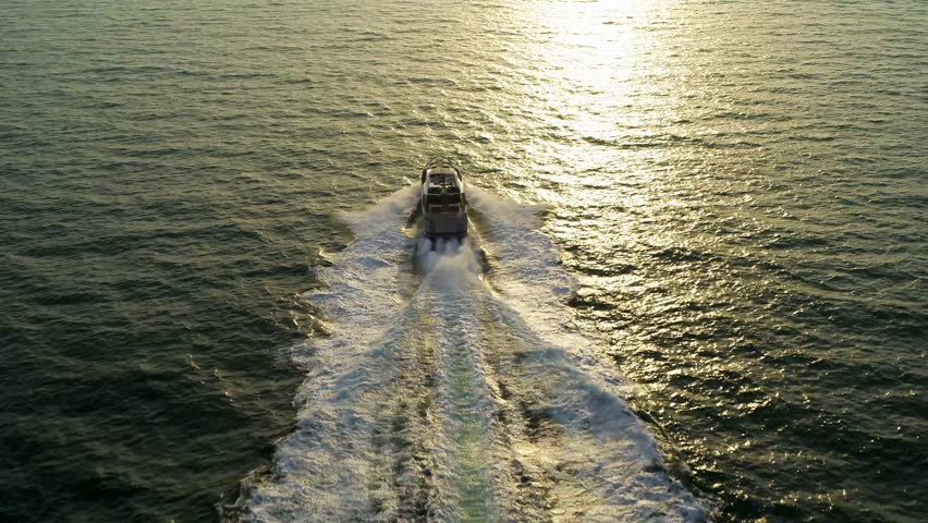 Aerial view of tranquil sunset with luxury yacht and motor boat in Dubai, United Arab Emirates.