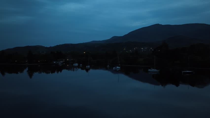 Flying over the lake in the night in Lake District, England