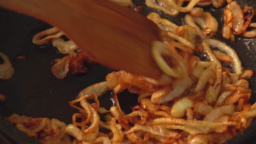 Close-up of delicious onion rings caramelizing in sugar on the pan. High quality 4k footage