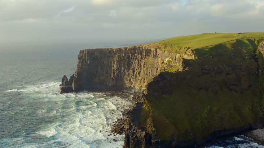 Northern Cliffs of Moher, windy and wavy evening, aerial view