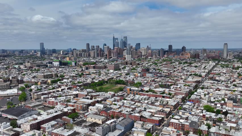 Philadelphia skyline, looking north bright spring day. Aerial orbit, zoom in. Large American city.