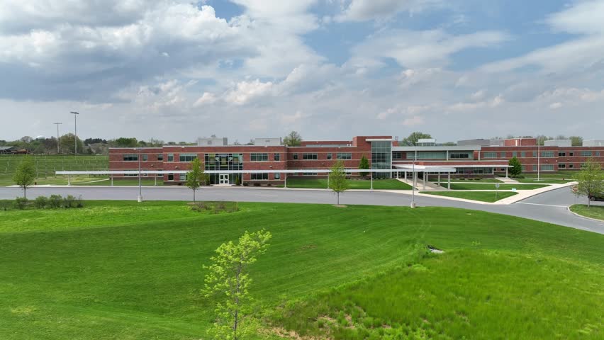 Aerial truck shot of modern public school. Large brick elementary school in USA. Bright spring day.