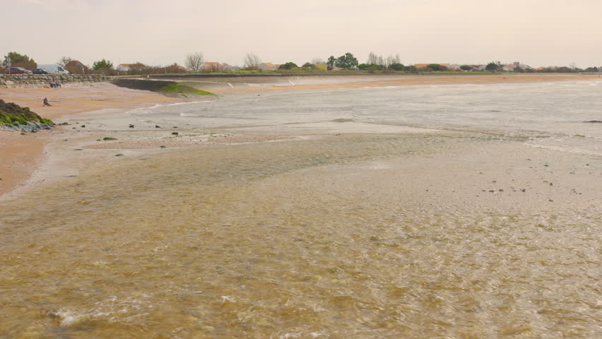Fresh River Stream Flowing Onto The Seascape With Calm Waves