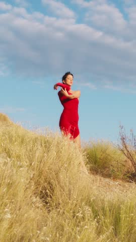 Young Woman In Red Dress Dances In The Nature Of The Tuscan Hill