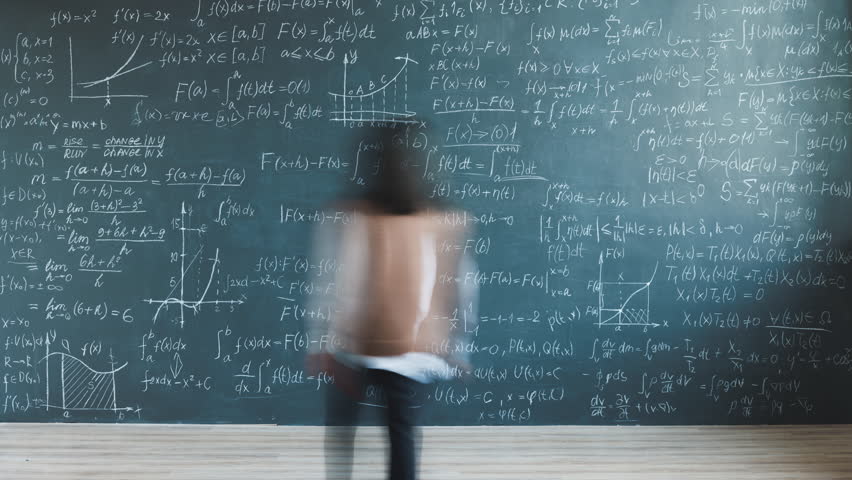 Zoom-in time lapse of young lady researcher solving equations writing on chalkboard in university laboratory. Science development and intelligent person concept.