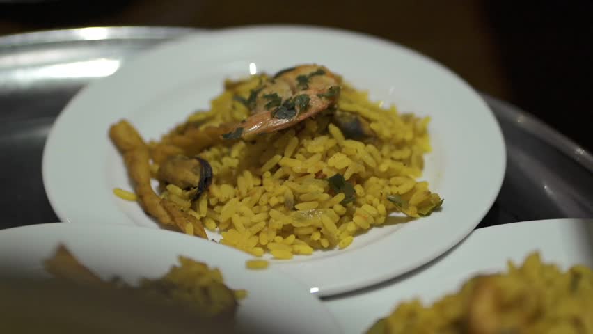 Several paella dishes in detail on a tray, ready to be served at the table - close up