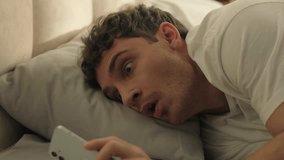 Man sleeping looking at screen mobile phone smartphone telephone late overslept male guy bedroom bed worried deadline morning routine stressed shocked rushing clock hurry punctuality panic quick fast - Powered by Shutterstock - Get 15% off with code: PIKWIZARD15