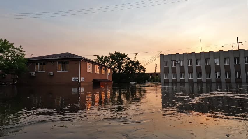 Flooded streets in Kherson town with beautiful sunset at background. Explosion of dam on Dnipro river in city of Novaya Kakhovka. Consequences of detonation of Kakhovka Hydroelectric Power Station