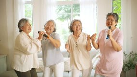 4K Group of Happy Asian senior women friends singing karaoke with dancing together in living room. Elderly retired people enjoy and fun indoor lifestyle spending time together with home entertainment. - Powered by Shutterstock - Get 15% off with code: PIKWIZARD15