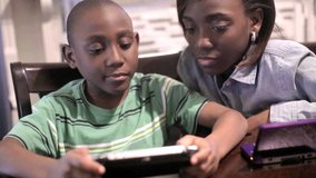 African American Black Boy and girl playing video games in the kitchen