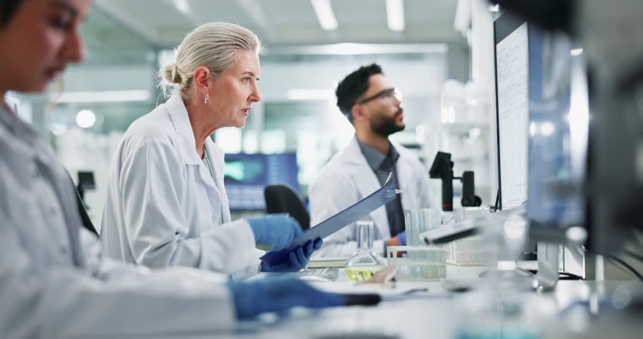 Clipboard, computer and science with team in lab for breakthrough, report or research. Collaboration, computer and innovation with people working together for pharmaceutical discovery or solution