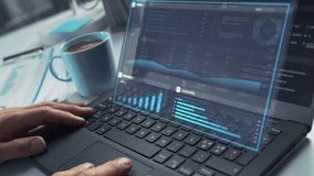 Close Up on Person's Hands Using a Laptop Computer with Analytical Data Presented in Futuristic Holographic Visualization with Graphs and Charts. Anonymous Man Working on Reports in a Modern Office - Powered by Shutterstock - Get 15% off with code: PIKWIZARD15