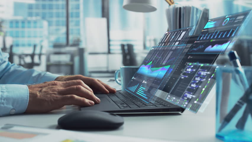 Close Up on Person's Hands Using a Laptop Computer with Analytical Data Presented in Futuristic Holographic Visualization with Graphs and Charts. Anonymous Man Working on Reports in a Modern Office