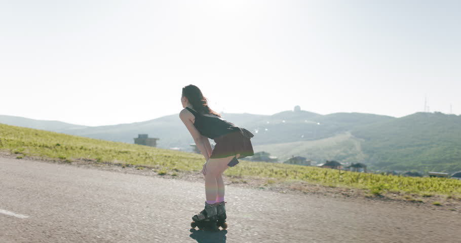 Young woman ride on roller skates outdoor with sunshine