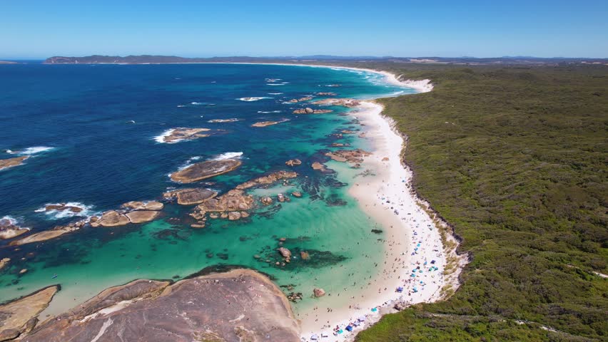 4K drone view of Greens Pool, a beautiful beach within the William Bay National Park in Denmark, Western Australia. The drone flies along as people enjoy the bautiful white sand beach below.