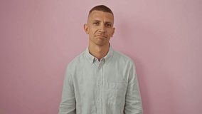 Young caucasian man posing humorously against isolated pink background showcasing playful expressions and gestures - Powered by Shutterstock - Get 15% off with code: PIKWIZARD15