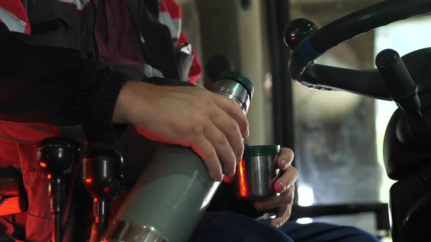 close-up the driver pours hot tea and coffee from a thermos