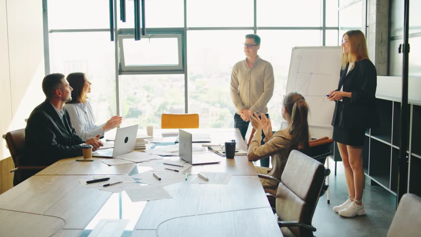 In the contemporary workplace, a group of coworkers comes together for a team meeting. They work on plans, exchange concepts, and review achievements as they strive towards their objectives