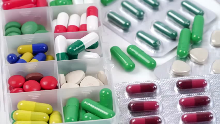 Antibiotic drug resistance, many colorful, red, yellow pills and capsules, packaging with medicines