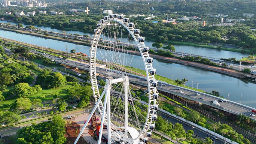 Ferris Wheel At Candido Portinari Park Sao Paulo Brazil. Aerial View Of Ferris Wheel Dominating Skyline Of City. Business Sky Clouds Downtown Cityscape. Drone View Downtown Panning Wide.