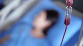 intravenous drip with sick person lying in hospital bed on background slow motion Healthcare, Person, hand with medical drip blurred background HD - Powered by Shutterstock - Get 15% off with code: PIKWIZARD15