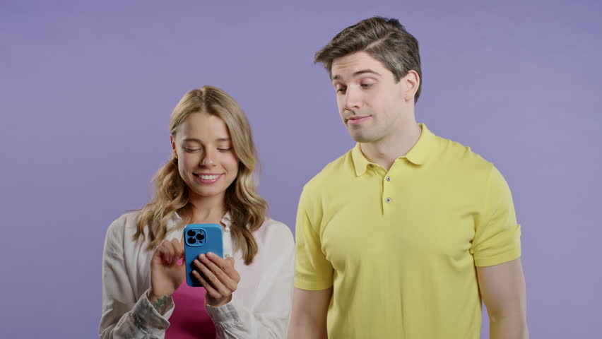 Suspicious man spying on girlfriend chats with smartphone. Jealousy, curiosity