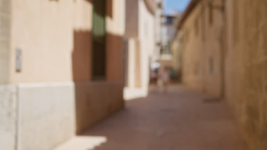 Defocused view of a narrow outdoor street in mallorca with a blurred background and bokeh effect